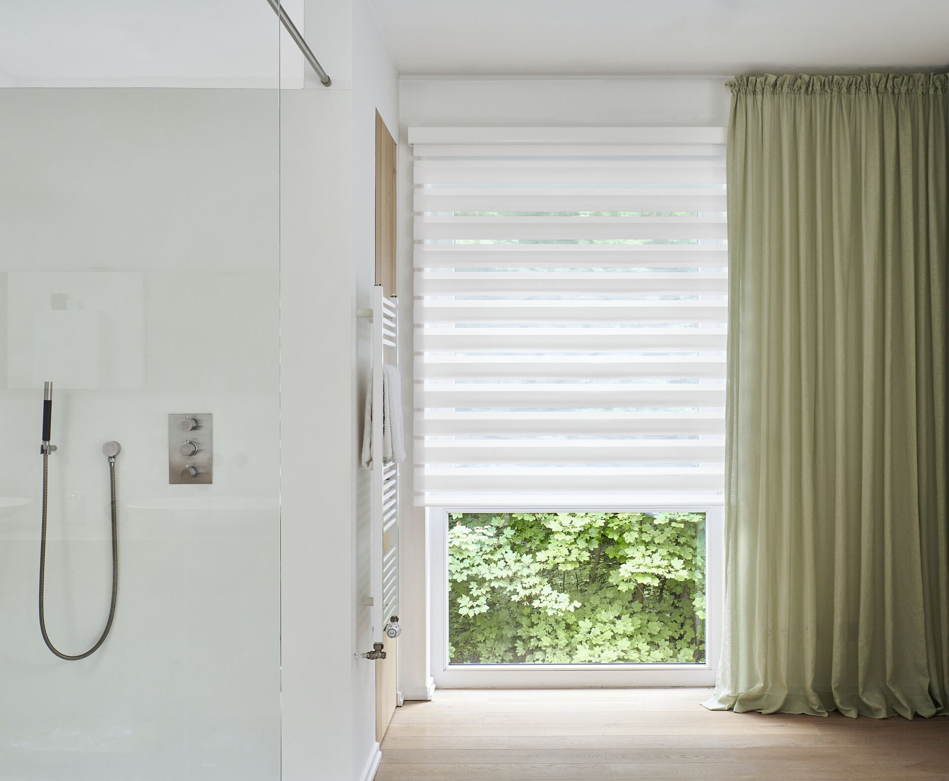 Weisses Doppelrollo am Badezimmerfenster neben der Dusche