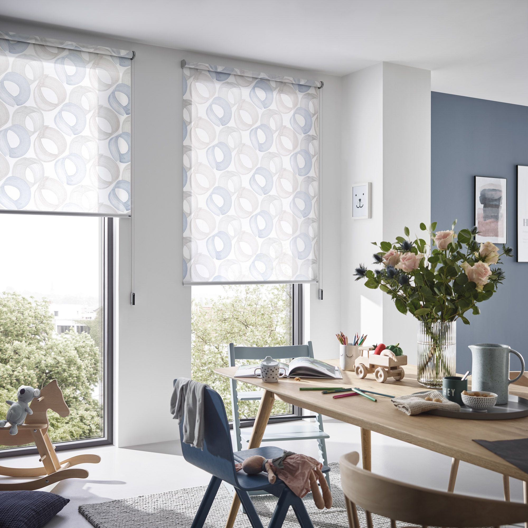 Zwei Rollos am Fenster mit Bedienkette und Kettenspanner an der Wand