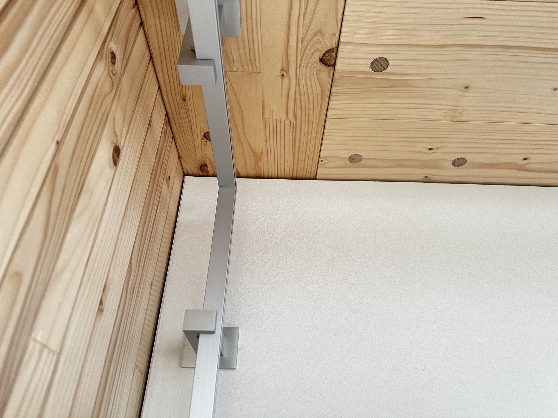 Aluminium-Vorhangprofil senkrecht über Eck geführt mit Deckenträger im Holzchalet